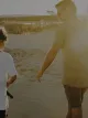 Man and boy walking on beach with fishing rods