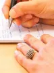 Close-up of two hands writing notes on paper