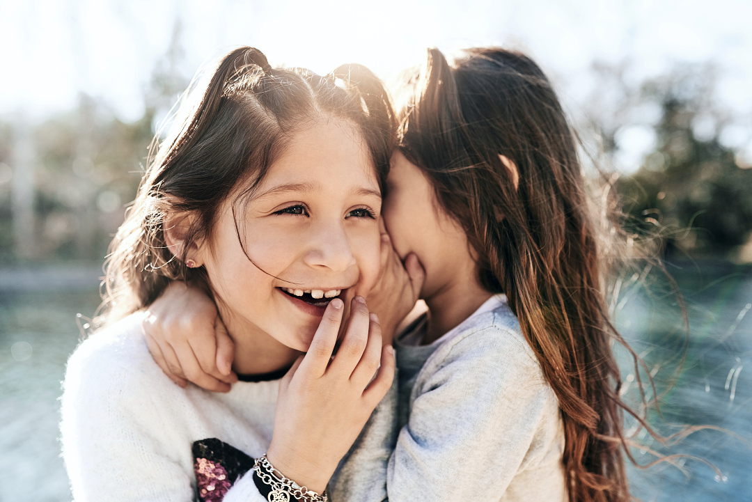 Girl whispering in ear