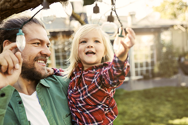 Father and child looking at garden lamps